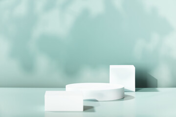 Empty cosmetics podiums on blue background with shadow and leaves for product