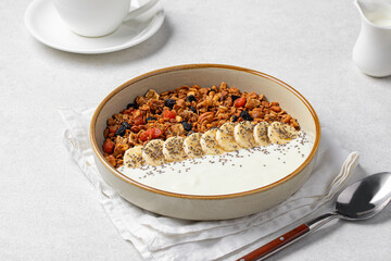Portion of gourmet granola breakfast with banana and yoghurt