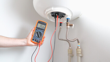 Men using multimeter to test heating element. Appliance engineer using a multimeter carrying out a...