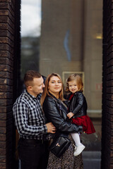 Parents and daughhter walking around the city. Spend time together. They are happy