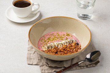 Portion of gourmet granola breakfast with banana and berry yoghurt