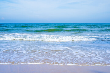Fototapeta na wymiar Light blue sea waves on a clean sandy beach..