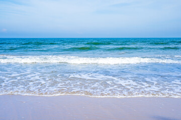 Fototapeta na wymiar Light blue sea waves on a clean sandy beach..