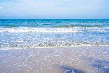 Light blue sea waves on a clean sandy beach..