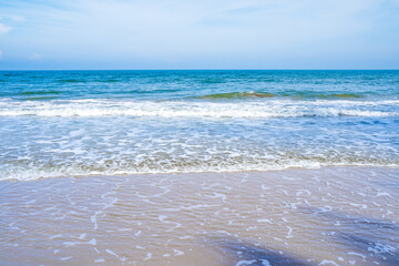 Light blue sea waves on a clean sandy beach..