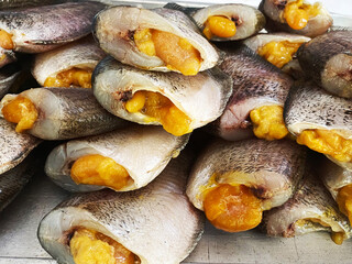 Dried snakeskin gourami placed on a table for sale. It is a popular food preservation in Thailand.