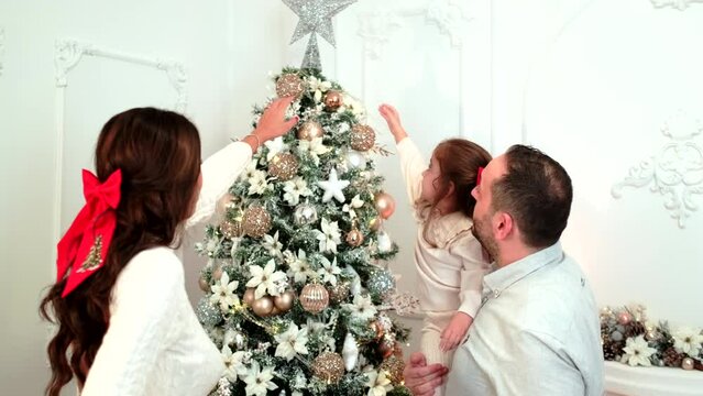 Happy family with causal clothes on a christmas day in front of a fireplace and a christmas tree.