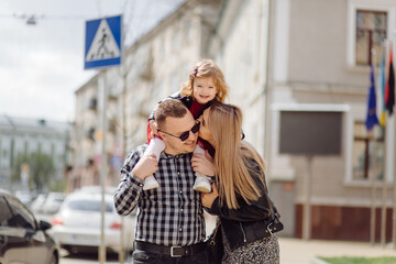 Parents and daughhter walking around the city. Spend time together. They are happy