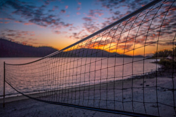 Obraz premium Volleyball net and beautiful sunrise on the beach