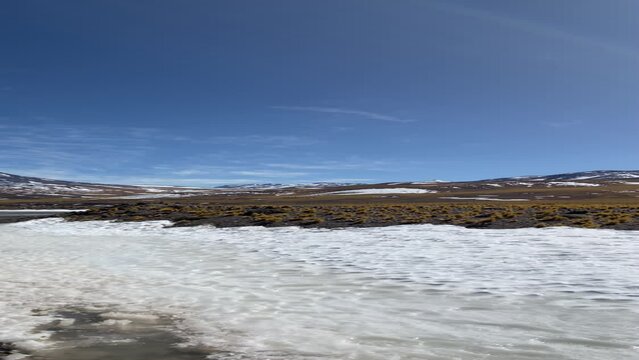Vertical low-angle shot of the Andes mountains snowy huge volcanoes iced water, Catamarca, Argentina