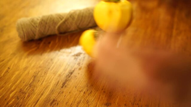 Woman hands preparing fresh persimmon fruit for drying, lined up on a rope. Row of Hanging Japanese dried Persimmon - Hoshigaki on strings to preserved it in autumn season. Selective focus