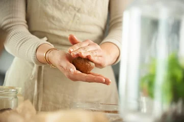 Keuken spatwand met foto Closeup of female hands forming pellets while making cookies ingredients around © Simone Oppes/Wirestock Creators