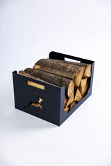 A metal box for firewood with wood logs in it on white background in a studio photoshoot. High quality photo