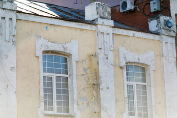A crumbling historic building in Russia. Historic building in poor condition. Windows of an old house.