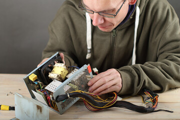 person checking computer power supply on table