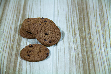 Pile of brown cookies against a wooden wall background
