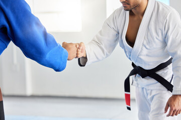 Karate, fighting tournament and men fist bump in martial arts competition for fighters with sportsmanship, honor and discipline. Man, judo fighters and self defense fight to win in dojo with respect - obrazy, fototapety, plakaty