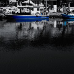 barca colorata e sfondo bianco e nero