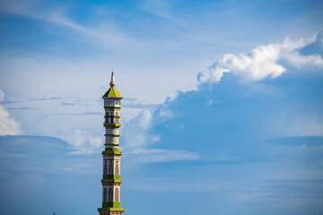 Fototapeta premium The mosque's domed minaret against the background of blue clouds