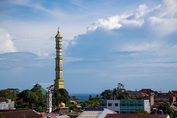 The mosque's domed minaret against the background of blue clouds