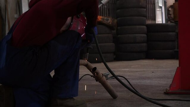 the welder performs welding works of metal structures for custom cars