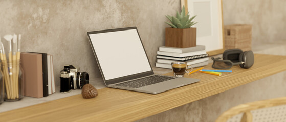 Minimal workspace with laptop mockup, books, stationery, headphones and decor on wood table