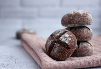 Fototapeta na wymiar round homemade gingerbread with cinnamon and powdered sugar on a gray background