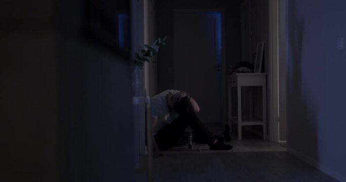 Pathetic drunk man drinks alone at home at night, alcoholism lifestyle