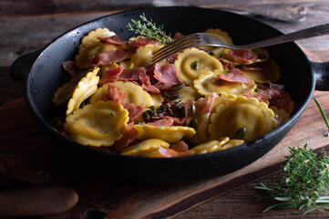 Ravioli with mushroom filling, italian ham, butter and pumpkin seeds