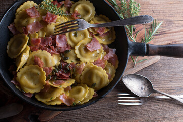 Italian pasta dish with ravioli and mushroom filling. Cooked with butter, ham, herbs and roasted...