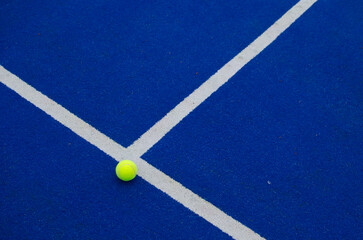 ball close to the line on a blue paddle tennis court