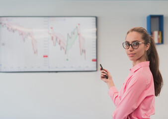 On Stage, Successful Female Speaker Presents Technological Product, Uses Remote Control for Presentation, Showing Infographics, Statistics Animation on Screen. Live Event Device Release.