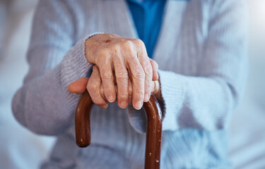 Hands, cane and disability with a senior woman closeup in her home alone with a walking stick for mobility. Health, medical and wellness with a mature female in a retirement home with hand wrinkles