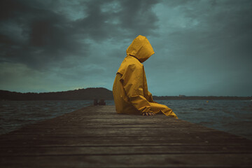 Hooded person with yellow jacket