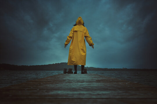 Person with yellow coat and dramatic cloudscape
