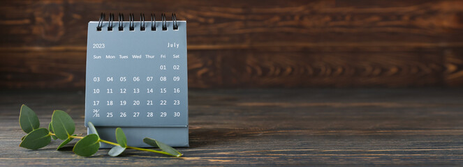 Flip paper calendar and eucalyptus branch on wooden background with space for text - obrazy, fototapety, plakaty