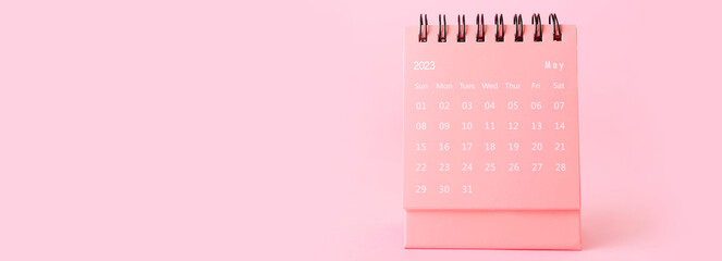 Flip paper calendar on pink background with space for text