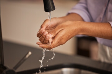 Washing hands, sink and water cleaning for wellness, health and hygiene hand care in a home. Person...