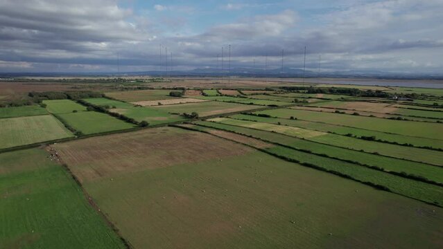 Panoramic aerial over farm fields toward Anthorn Radio Station, Cumbria, UK
