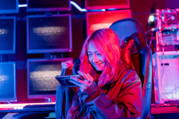 Winning or You Win. Young woman gamer champion excited, Happy gamer people playing video game online with smart mobile phone with neon lights raises hands to wins celebrating, game and e-sports.