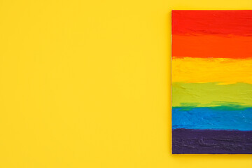 Painting of LGBT flag on yellow wall