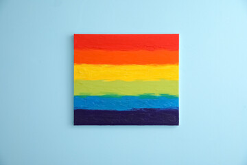 Painting of LGBT flag on blue wall