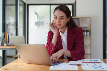 Female employee using laptop at workplace. Businesswoman preparing economic report by laptop...