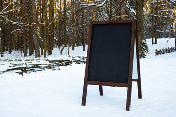 Close up of chalkboard menu outside on the snow. Winter menu display in the mountains.