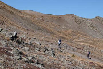Pair of hikers with their baby in backpack on ascent from Lac de l'Oule to Col de l'Oule, north of...