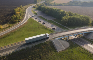 Truck with Cargo Semi Trailer Moving on Rural Road in Direction. Aerial Top View - obrazy, fototapety, plakaty