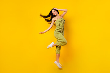 Full size portrait of nice peaceful person jumping hand touch head isolated on yellow color background