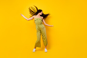 Full body photo of pretty positive girl flying hair enjoy dancing partying isolated on yellow color background