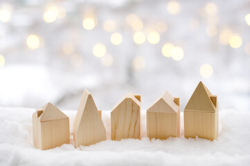 Fabulous winter town. Toy wooden houses on white snow background of a beautiful bokeh. Happy New...