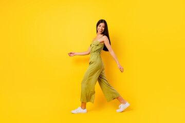 Fototapeta na wymiar Full body profile portrait of adorable positive girl walk toothy smile isolated on yellow color background